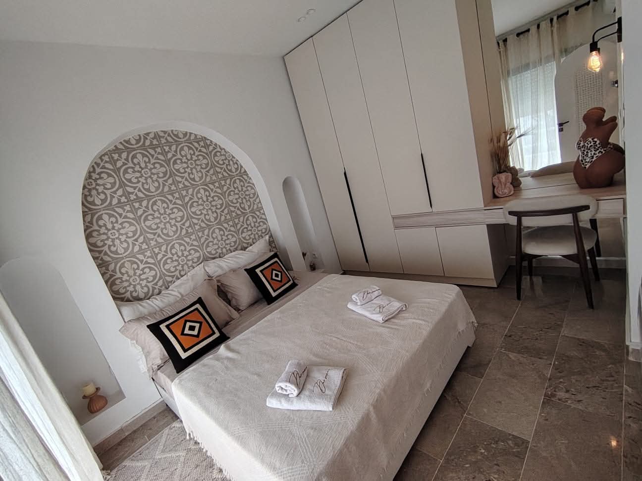 Bedroom with mosaic headboard, wardrobe and vanity